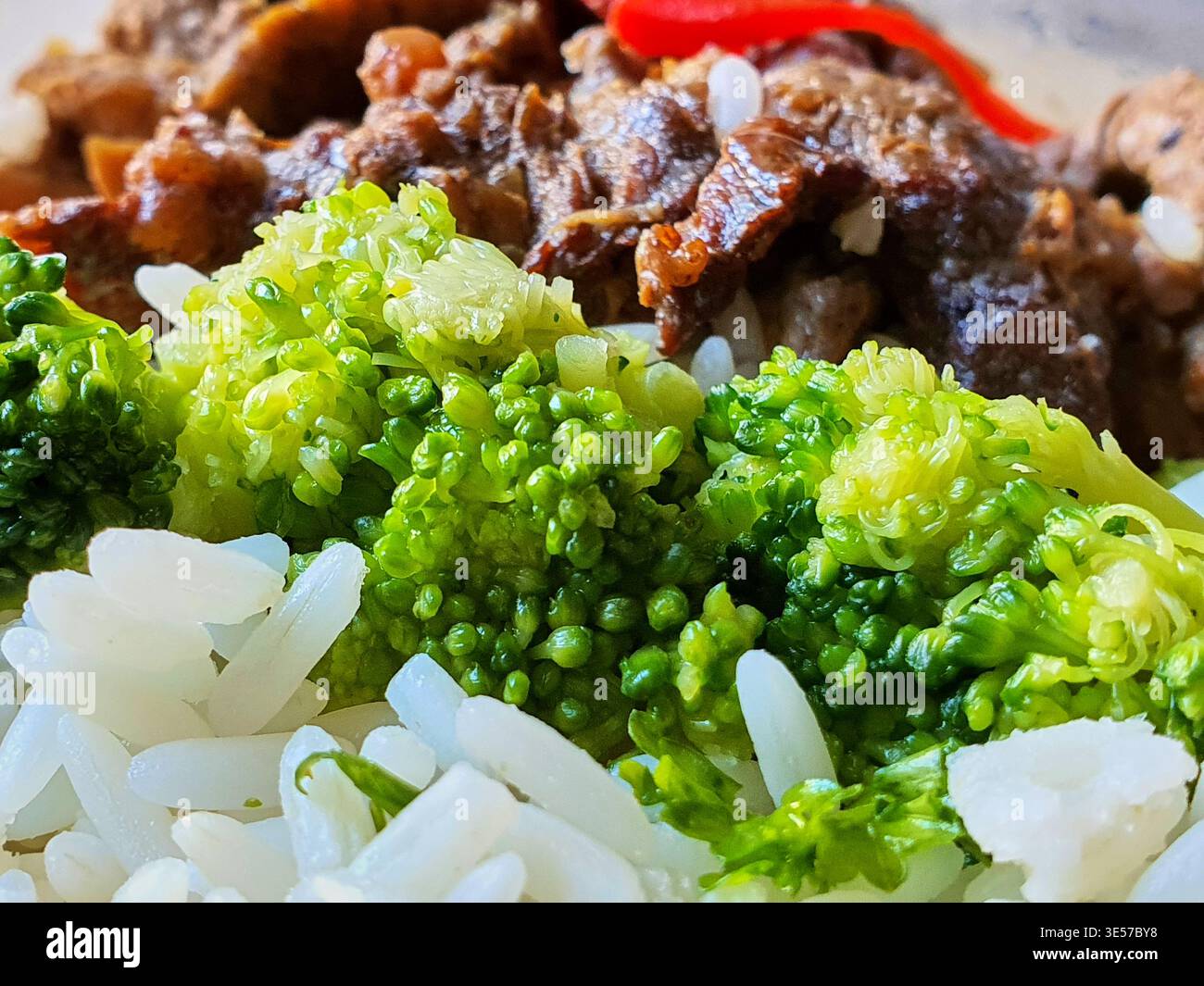 Foto macro di un primo piano estremo di una composizione di un pasto in stile asiatico. Il primo piano presenta distinti chicchi di riso al gelsomino bianco con visibile Foto Stock