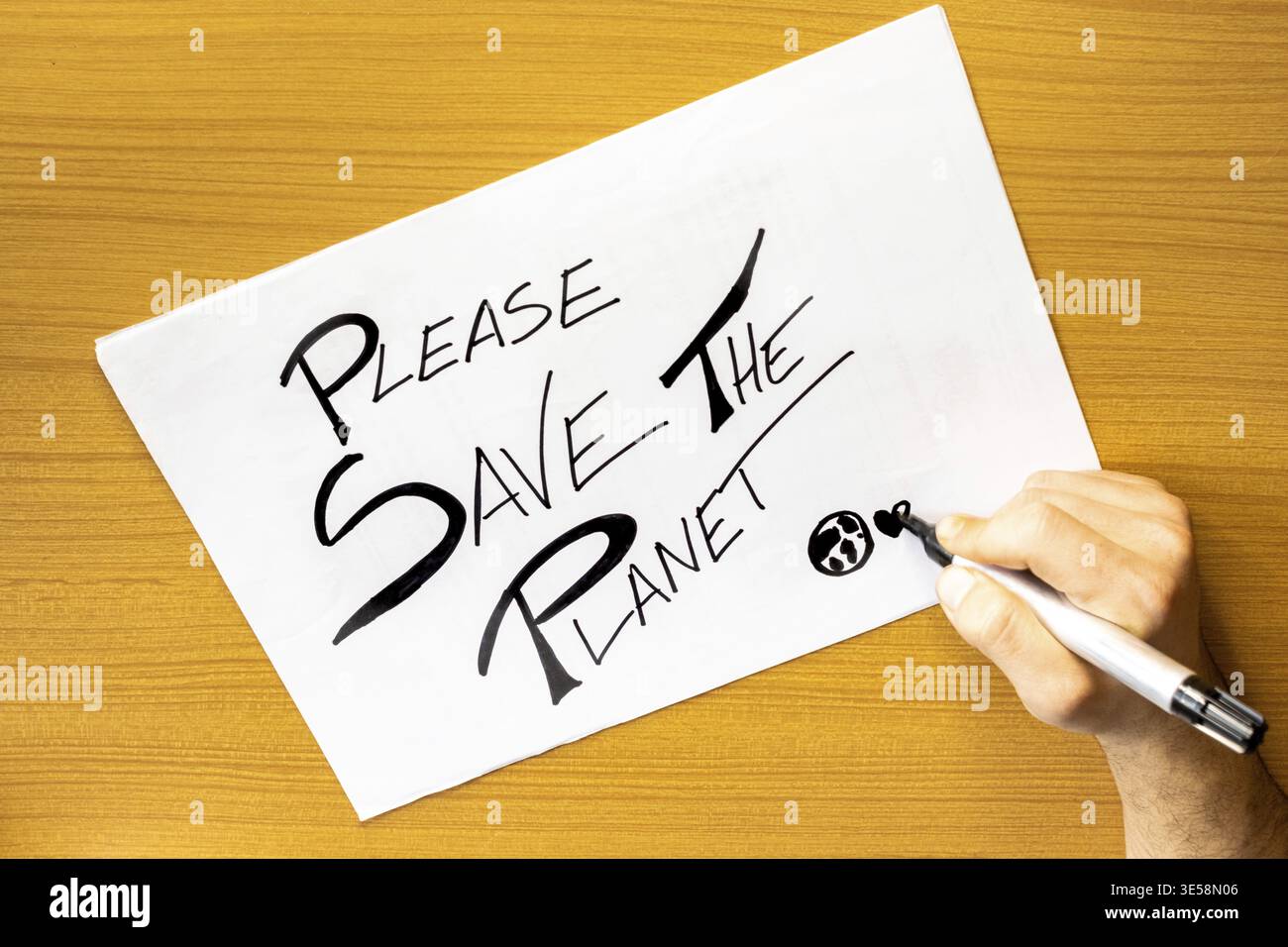Mano con carta sul tavolo SALVARE IL PIANETA, messaggio su cartone salvare IL pianeta, concetto di scrittura a mano su cartone SALVARE LA TERRA Foto Stock