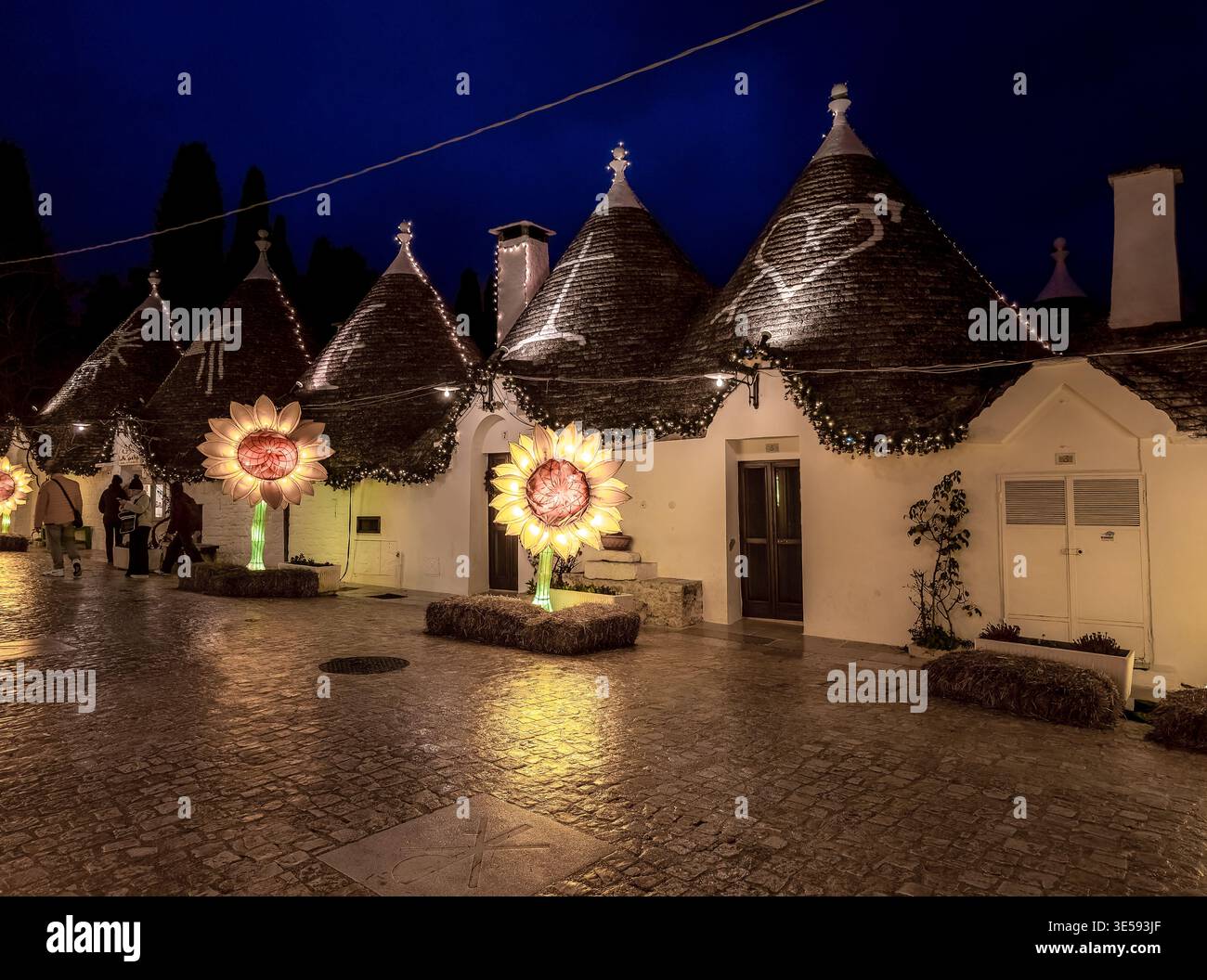 Incantevoli Trulli di Alberobello di notte con luci di girasole - iconici tetti in pietra conica in Puglia Italia - Villaggio Patrimonio dell'Umanità dell'UNESCO Foto Stock