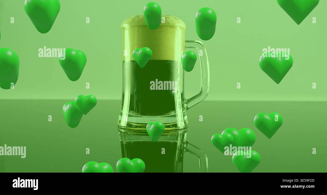 Esposizione di tazza in vetro trasparente con schiuma ricoperta di bevanda verde sul tavolo da studio con cuori fluttuanti Foto Stock