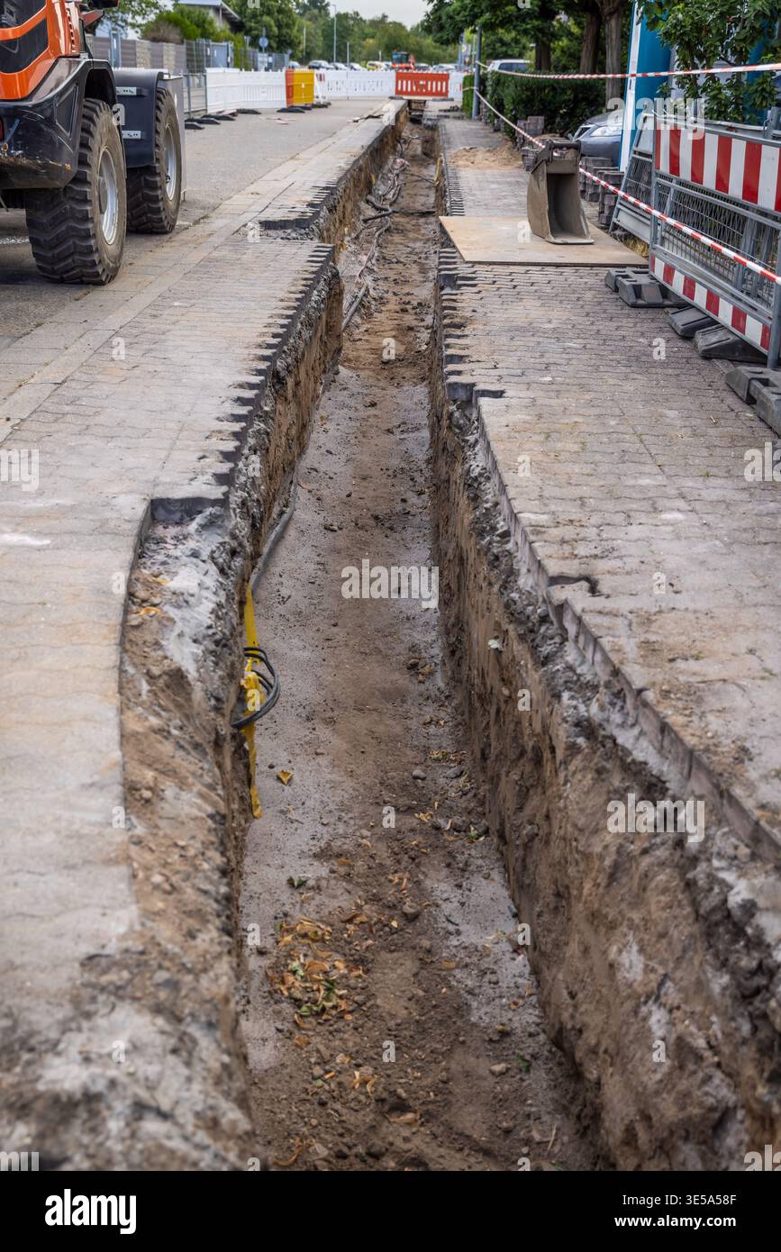 Costruzione di utenze sotterranee per tubi, linee di pubblica utilità in una strada, sotto la strada. Foto Stock