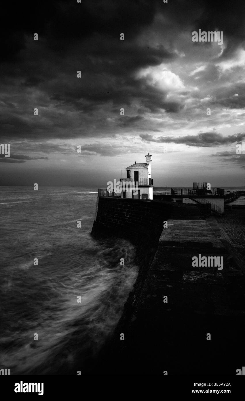 Vista a lunga esposizione in bianco e nero della storica Signal House nel porto di Arbroath dalla frangiflutti di pietra, Angus, Scozia. Foto Stock