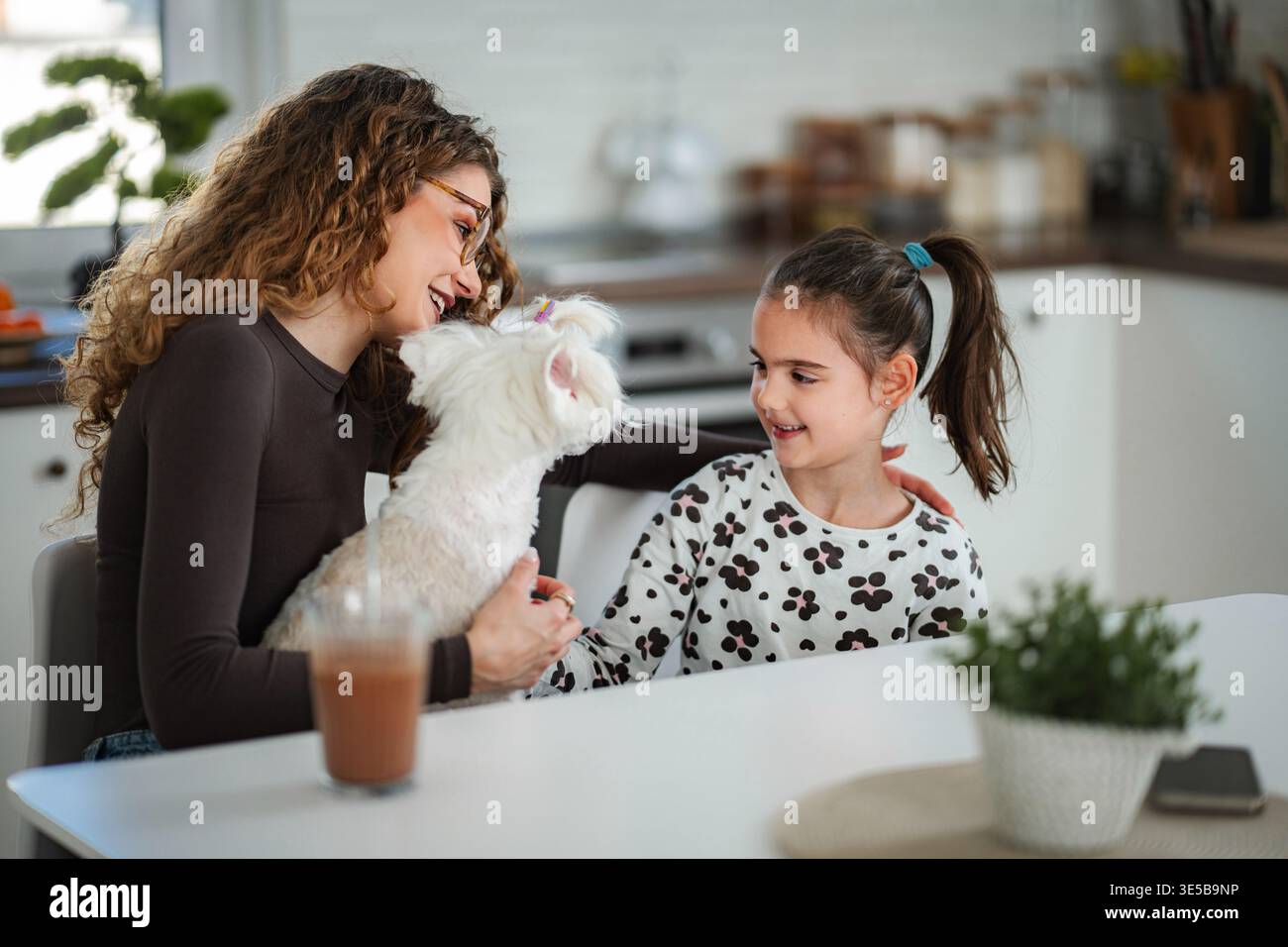 Madre e figlia felici si legano con il cane Foto Stock