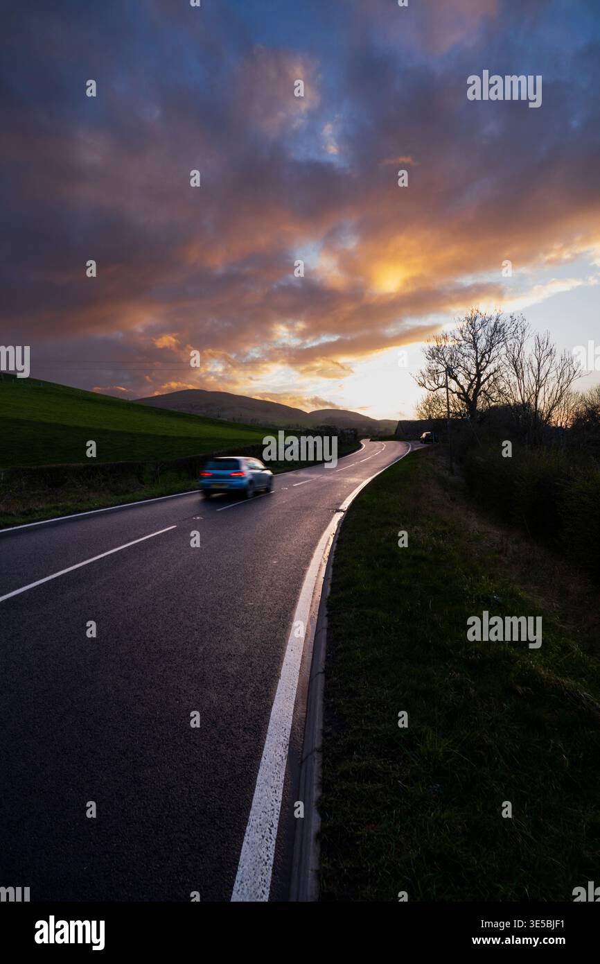 La tortuosa strada A697 a nord di Wooler, Northumberland, st Sunset iat alla fine di marzo Foto Stock