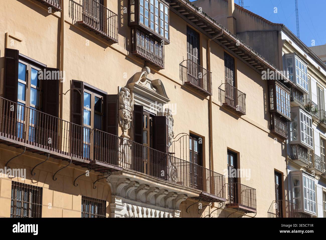 Architettura storica nella soleggiata Malaga, in Spagna, con eleganti balconi e intricati lavori in pietra Foto Stock