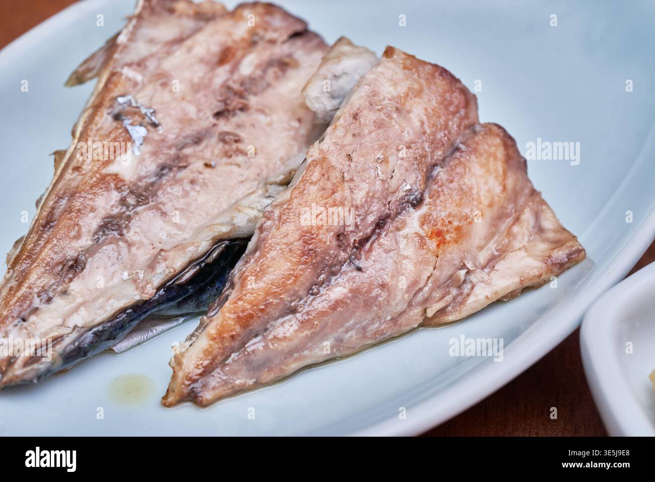 Classici piatti coreani di sgombro. Mostra il rosso piccante e vivace di una salsa di patate e la perfezione croccante, dorata e oleosa del manzo alla griglia salato Foto Stock