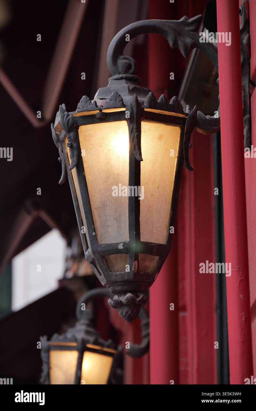 La vecchia lampada dona una calda luce soffusa nelle strade della città di notte Foto Stock