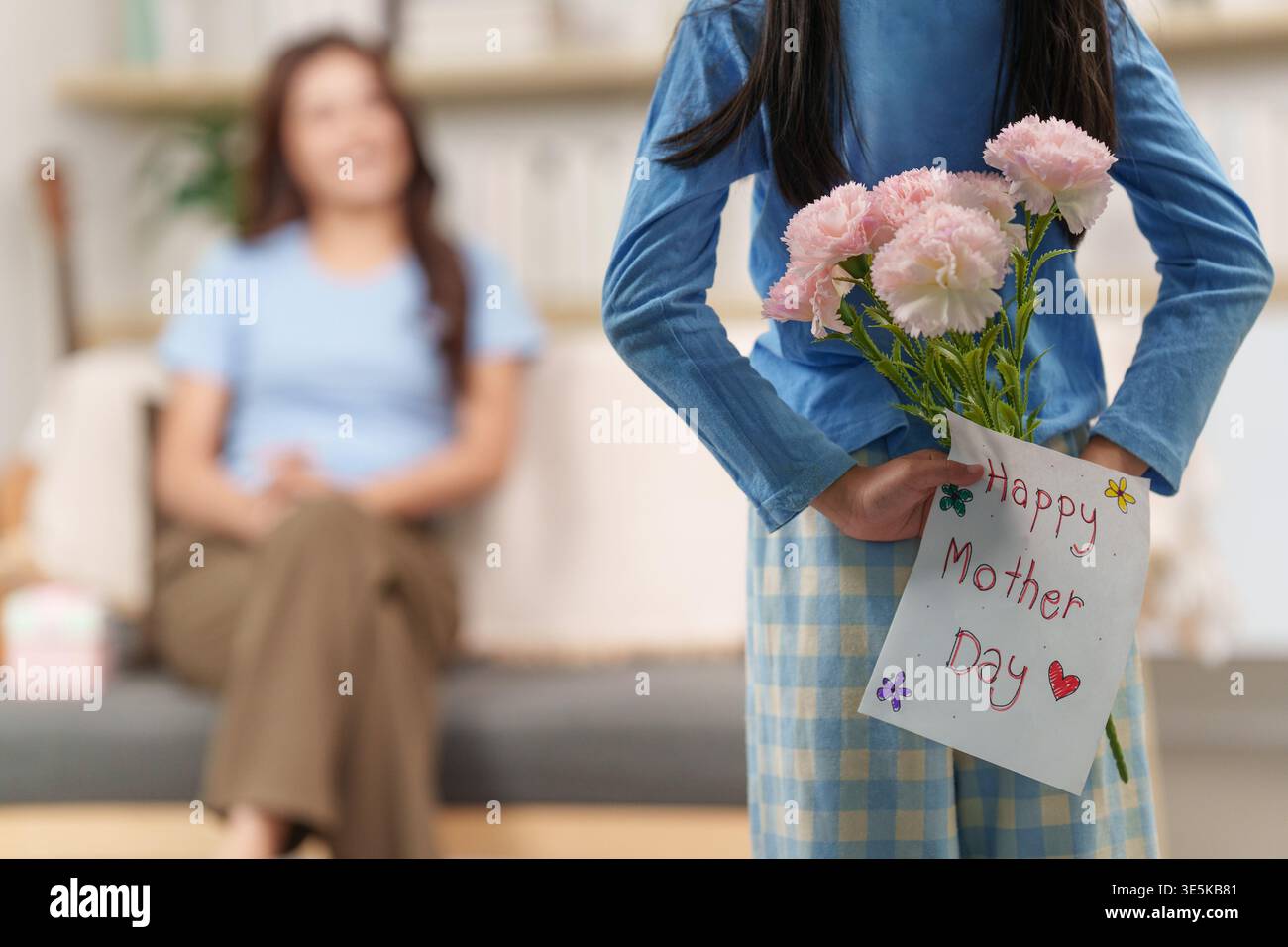 Bambini che donano fiori e tessera per la festa della mamma Foto Stock