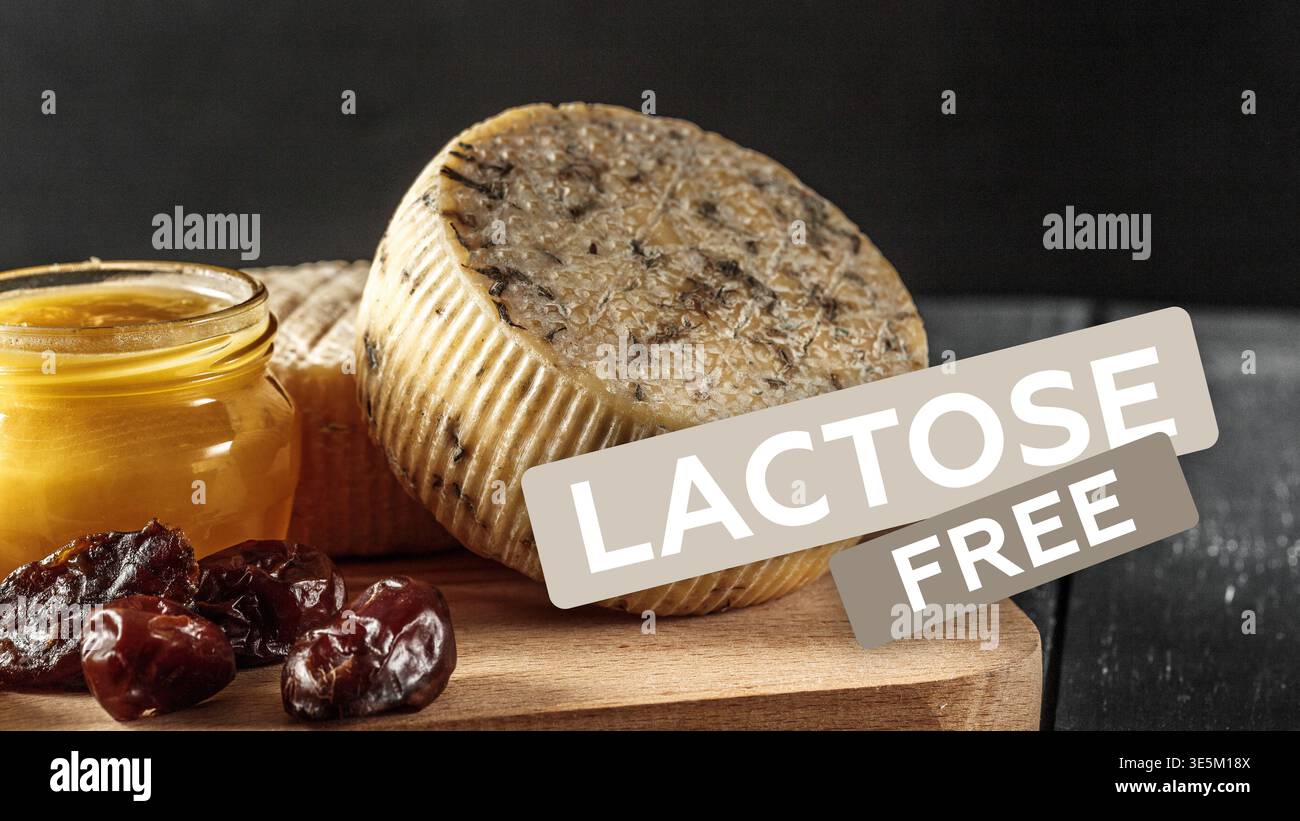 Formaggio senza lattosio su tavola di legno con miele e frutta secca in cucina Foto Stock
