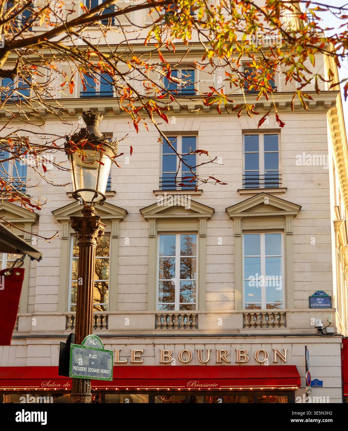 Parigi, Francia. 13 ottobre 2025. Caffè le Bourbon a Parigi, in Francia, con foglie d'autunno, una lampada da strada ornata e la classica architettura Haussmann Foto Stock