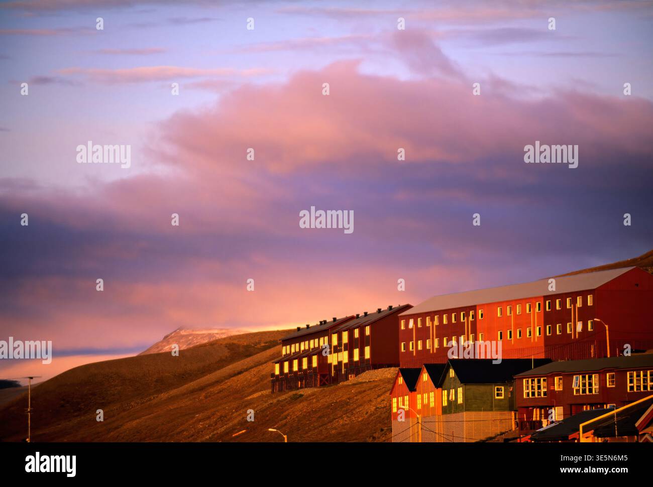 Longyearbyen nelle Svalbard mostra edifici colorati al tramonto. Il cielo cambia colore man mano che il giorno diventa notte in questa città artica. Foto Stock