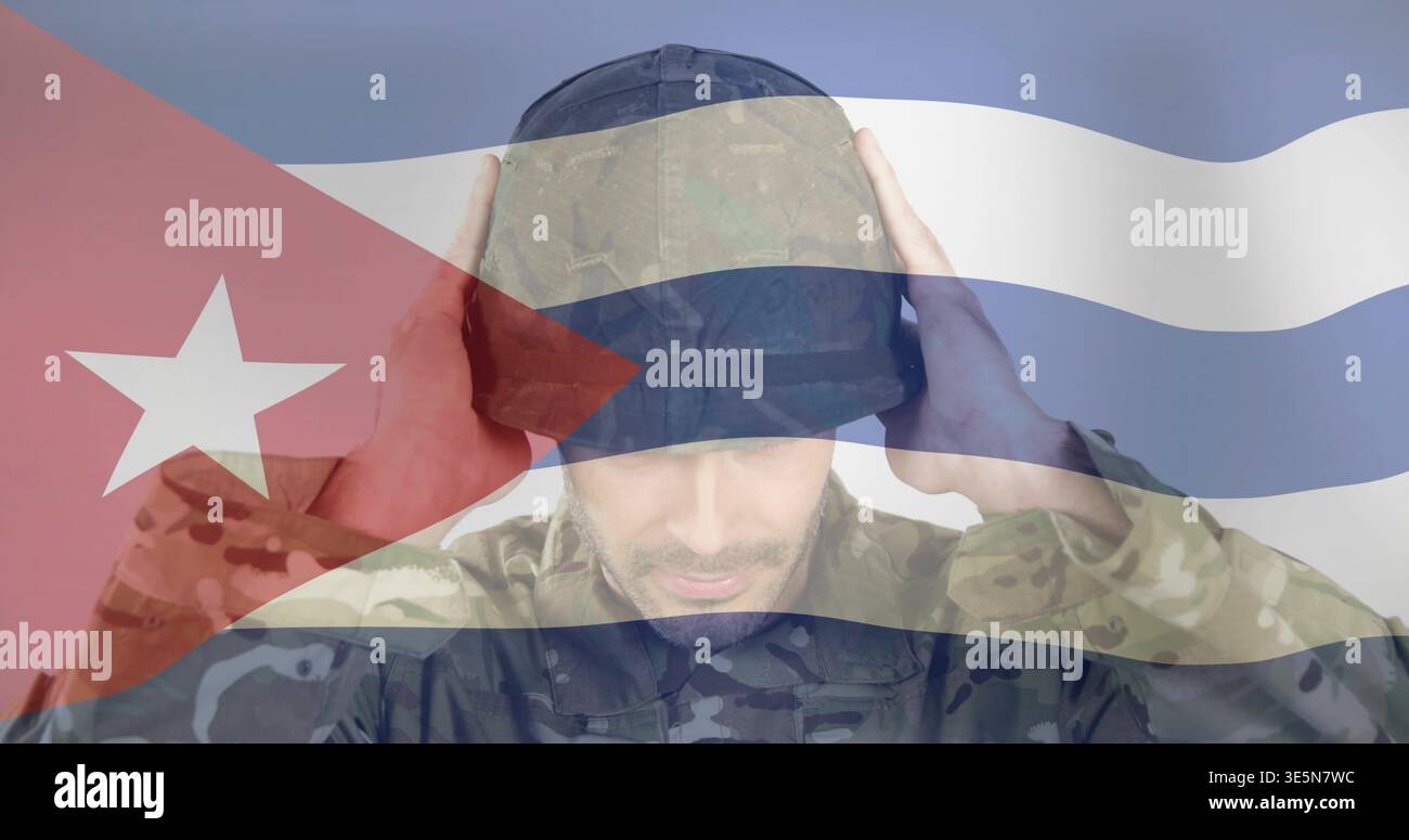 Alzando entrambe le mani soldato adulto toccando il berretto scuro in studio con mascherina camouflage della bandiera cubana Foto Stock