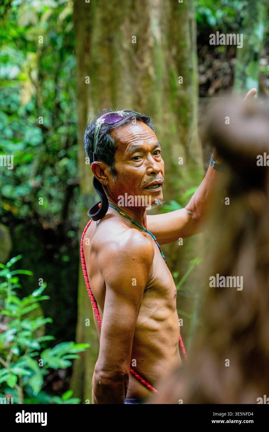 Uomo indigeno che condivide la conoscenza nel paesaggio della giungla Foto Stock