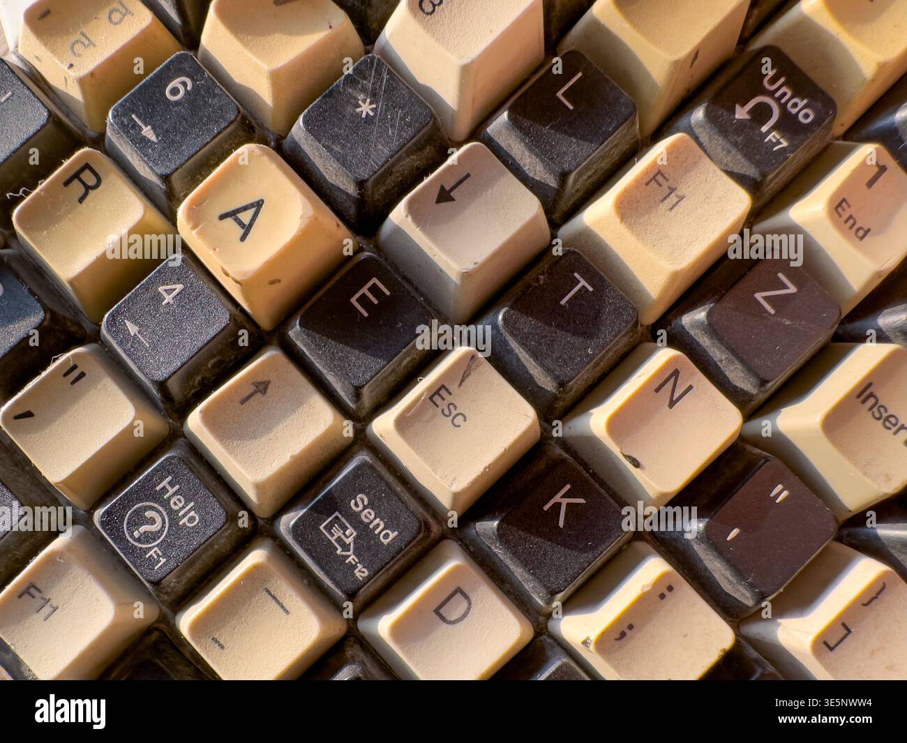 Tastiera per computer d'epoca con superficie beige invecchiata e pulsanti intemprati. Gli artefatti della tecnologia desktop rétro evocano nostalgia, il computing classico e l'alta qualità Foto Stock