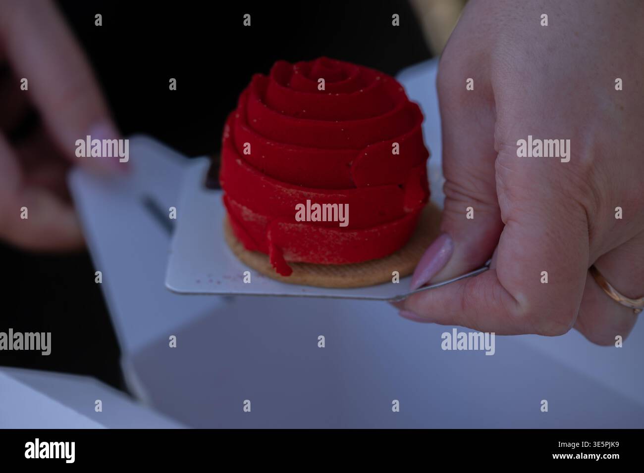 Il dessert con mousse rossa viene servito a mano con un concetto di pasticceria di lusso Foto Stock