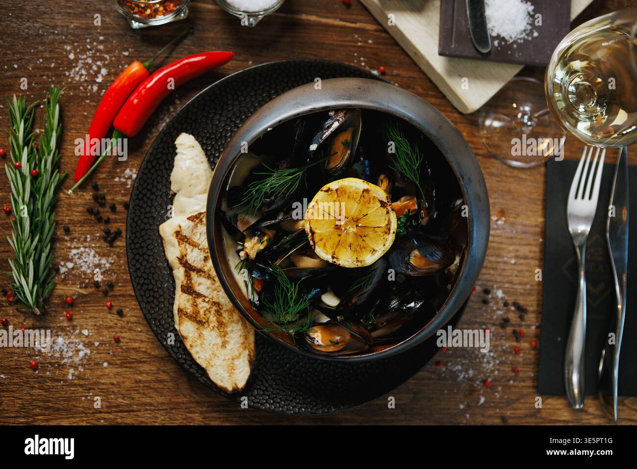 Cozze in stile ristorante con pane, limone e spezie Foto Stock