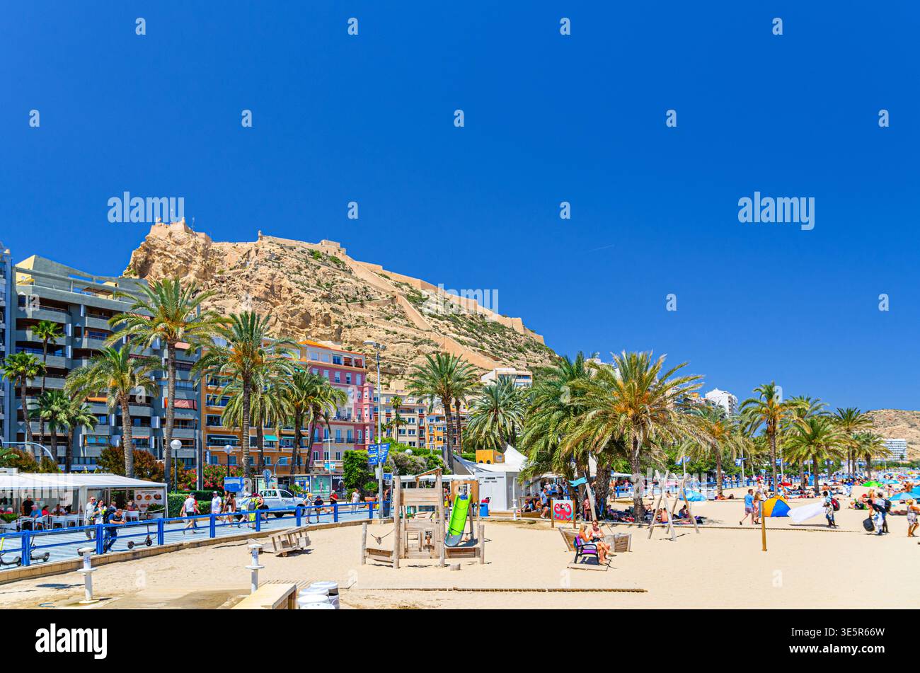 Alicante, Spagna, 29 maggio 2025: Persone che si rilassano sulla spiaggia di Playa del Postiguet nella soleggiata giornata estiva nel centro storico di Alicante, Castillo Foto Stock
