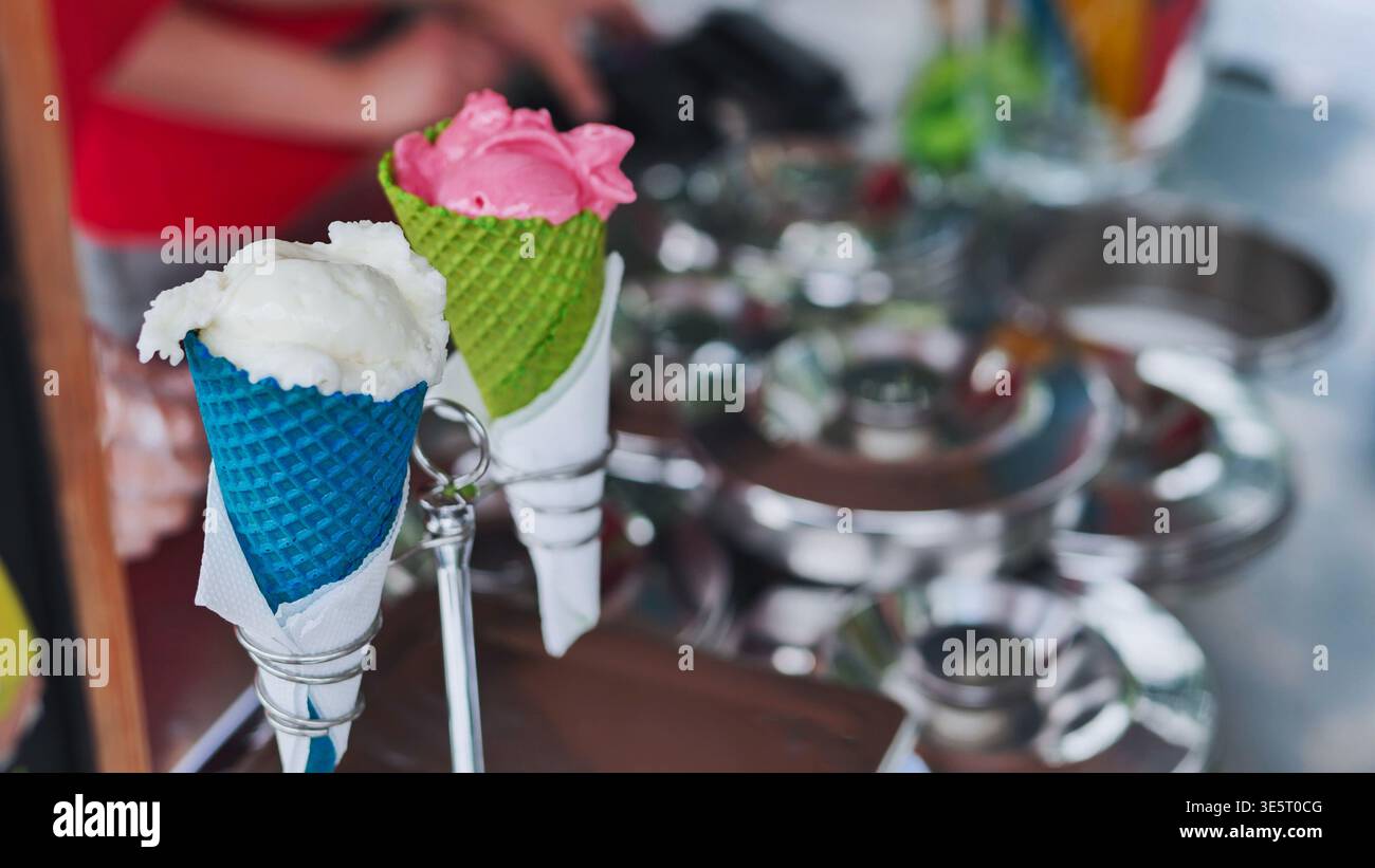 Coni di gelato colorati in tazze di cialde vendute presso uno stand del mercato del cibo di strada Foto Stock