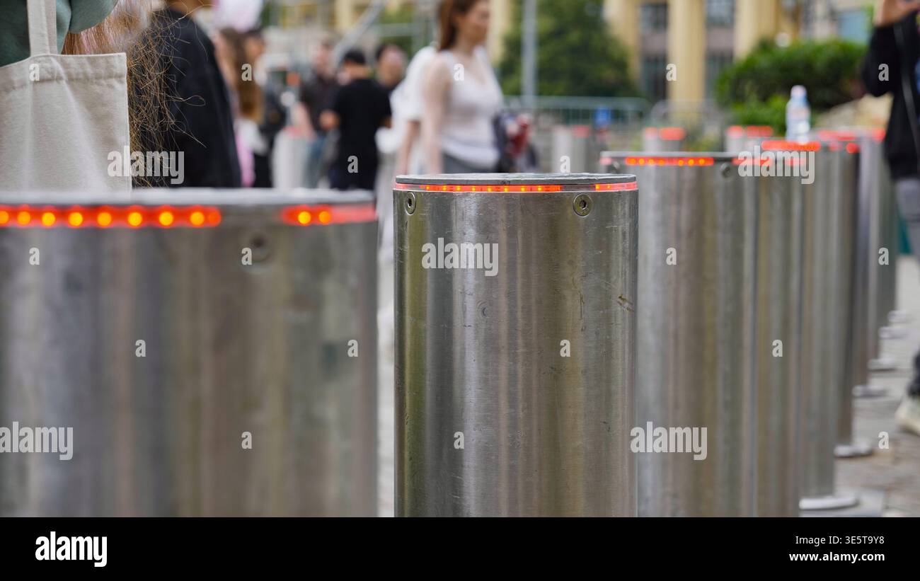 Regolazione dell'accesso urbano: Dissuasori in metallo con luci rosse che controllano il flusso del traffico Foto Stock