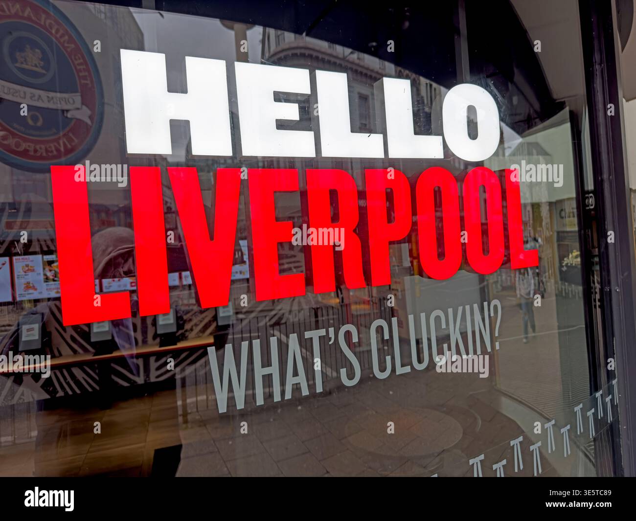 Cartello della finestra KFC con la scritta "Hello Liverpool, What's cluckin?" Nel centro di Liverpool, che illustra il marchio del pollo fritto e la cultura da asporto. Foto Stock