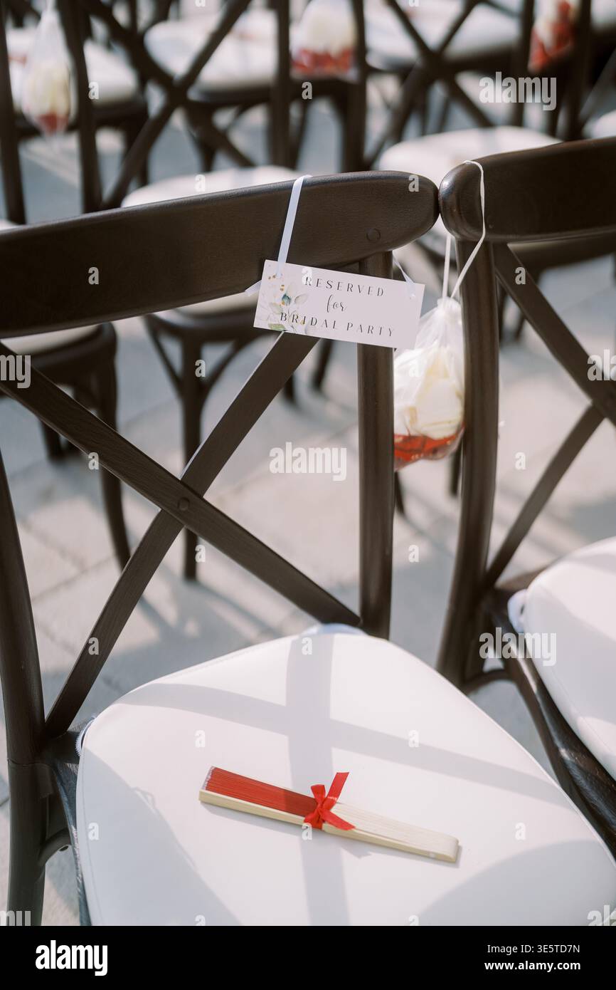 Allestimento per matrimoni con sedie nere e cuscini bianchi Foto Stock