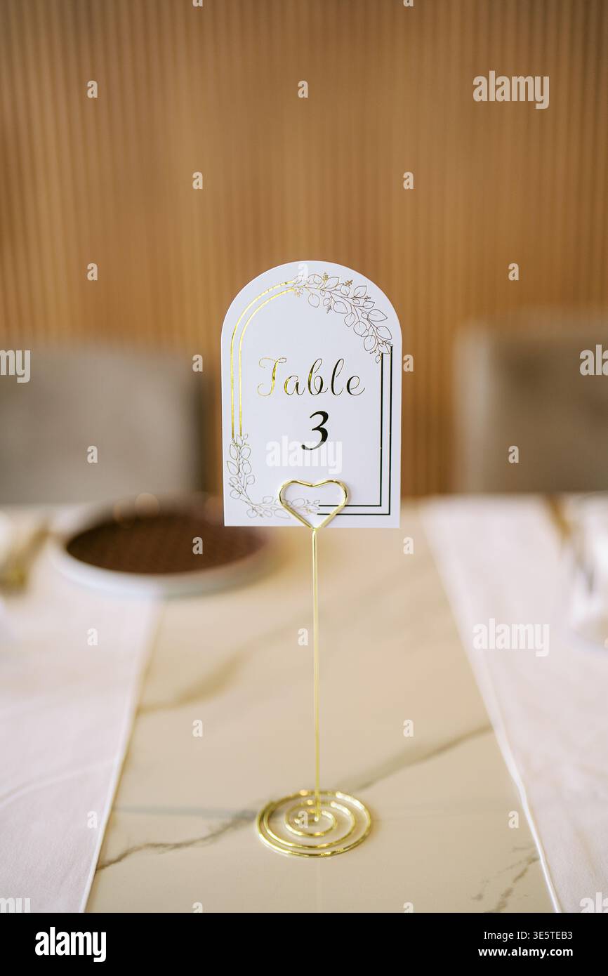 Sofisticato supporto dorato che incornicia il moderno tavolo per eventi Foto Stock