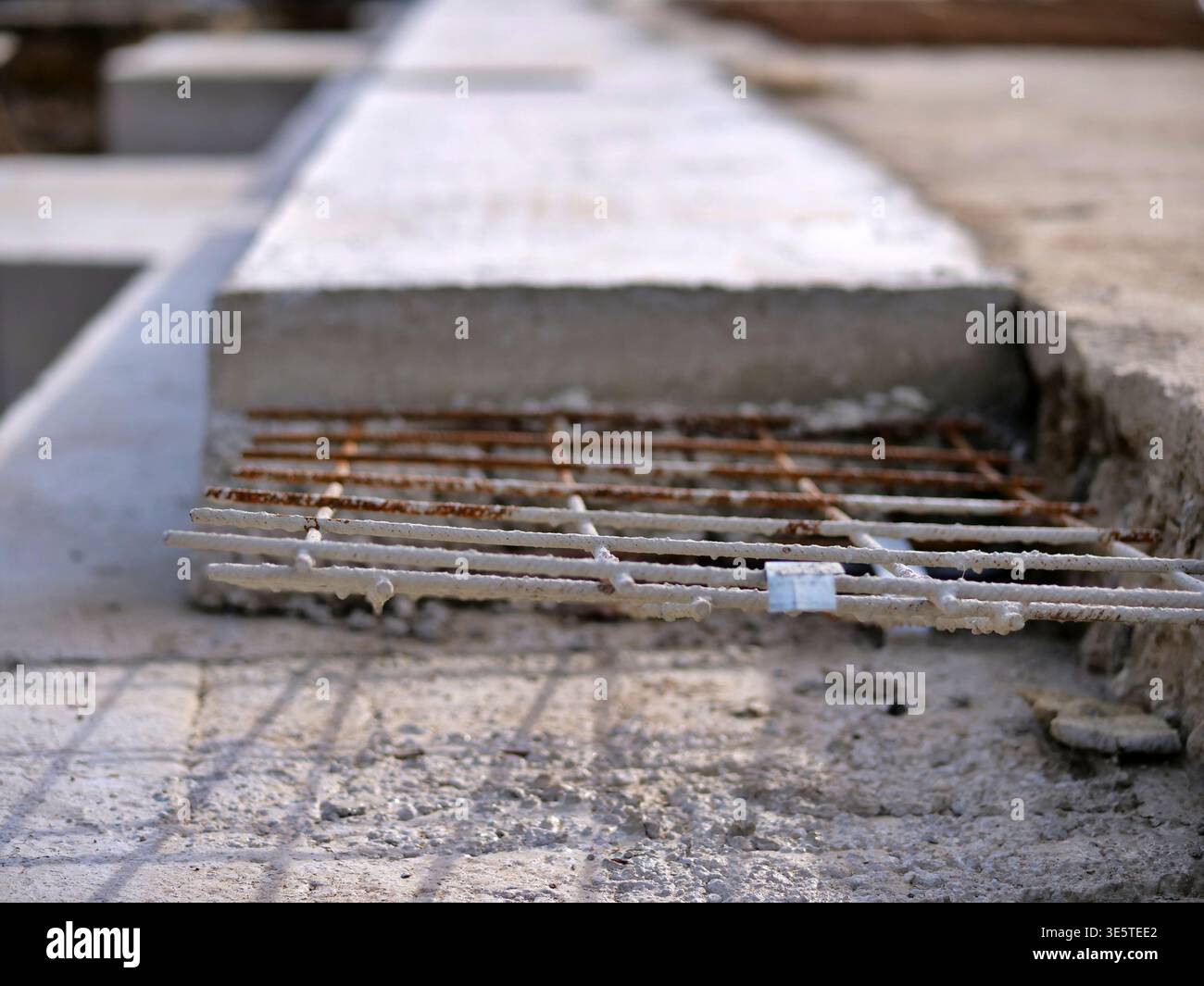 Soletta in cemento armato da primo piano con rete in acciaio, arrugginito che sporge dal bordo del cemento, dettaglio del pavimento del cantiere industriale, edificio grezzo Foto Stock