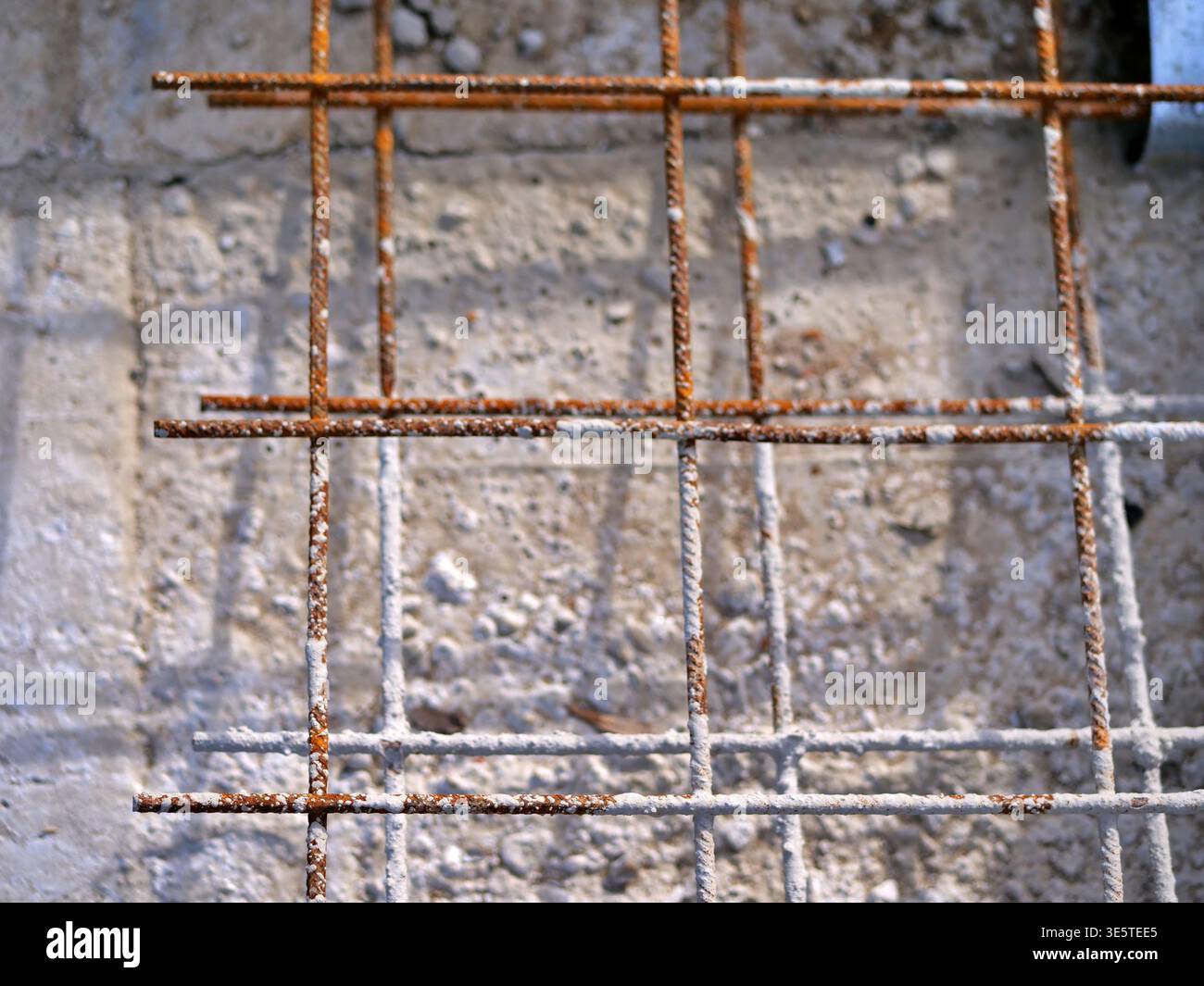 Vista dall'alto verso il basso della rete di armature in acciaio arrugginito su calcestruzzo, griglia di rinforzo per costruzioni industriali, primo piano di aste in ferro per fondamenta edili, archi Foto Stock