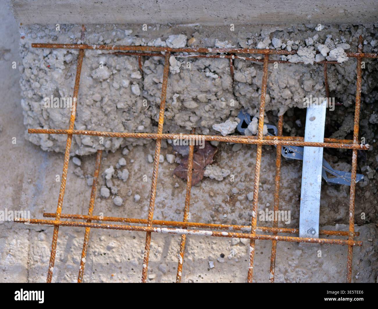 Vista dall'alto verso il basso della rete di armature in acciaio arrugginito su calcestruzzo, griglia di rinforzo per costruzioni industriali, primo piano di aste in ferro per fondamenta edili, archi Foto Stock