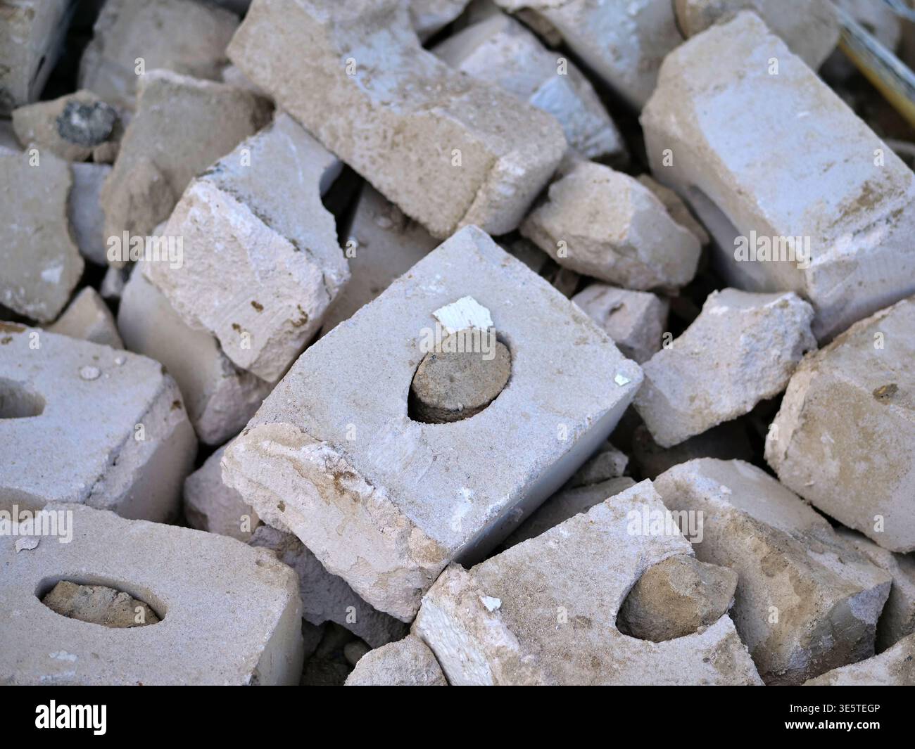 Un mucchio di blocchi di muratura bianca rotti e macerie di calcare in un cantiere edile, primo piano di detriti di pietra di colore chiaro con nuclei cavi, schiacciati Foto Stock