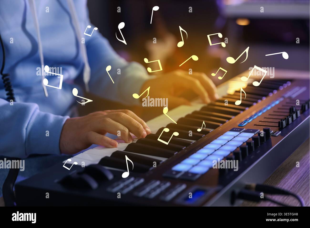 Uomo che lavora con la tastiera MIDI a casa, primo piano. Note musicali che volano sopra lo strumento elettronico Foto Stock
