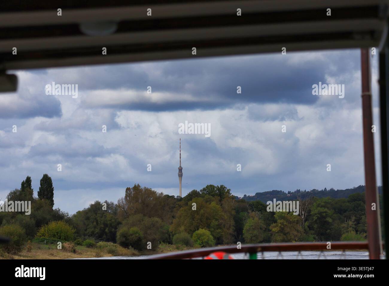 Blick vom Elbdampfer auf den Dresdner Fernsehturm: Perspektive vom Schiffsdeck über die Elbwiesen auf das markante Wahrzeichen in Sachsen Foto Stock