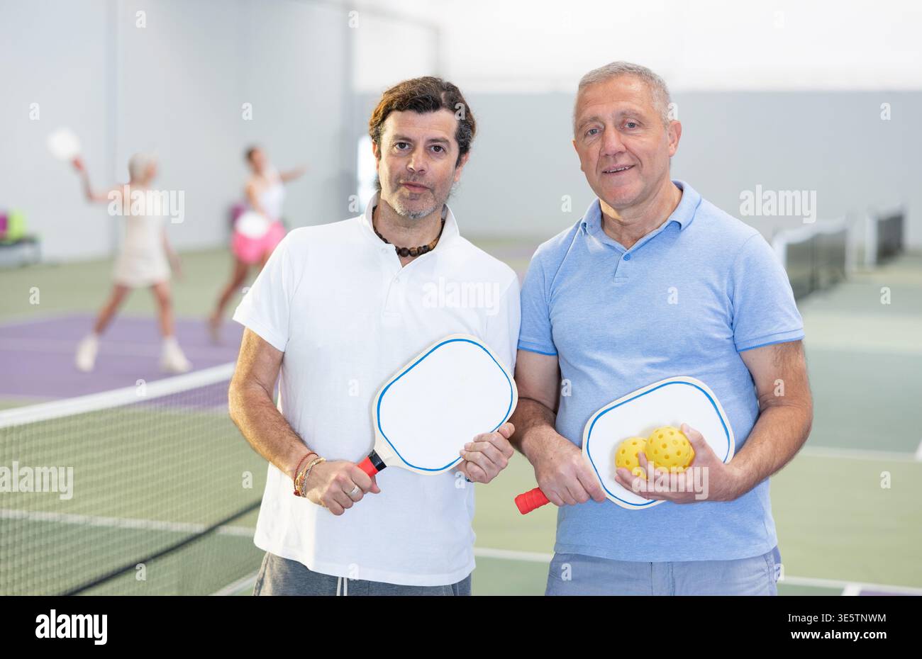 Due giocatori maschi di pickleball in piedi sul campo interno Foto Stock