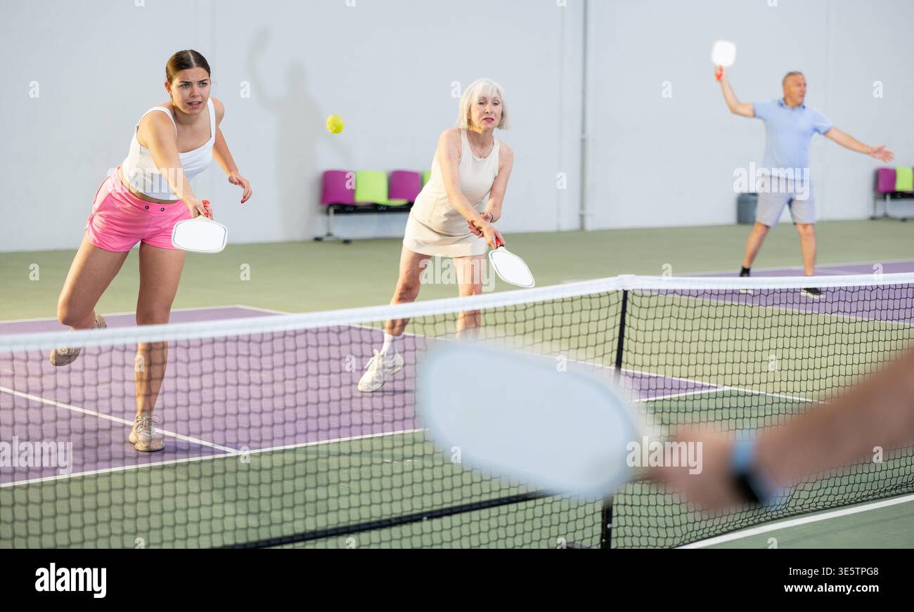 Donne che giocano a Pickleball tennis sul campo da Pickleball al coperto Foto Stock