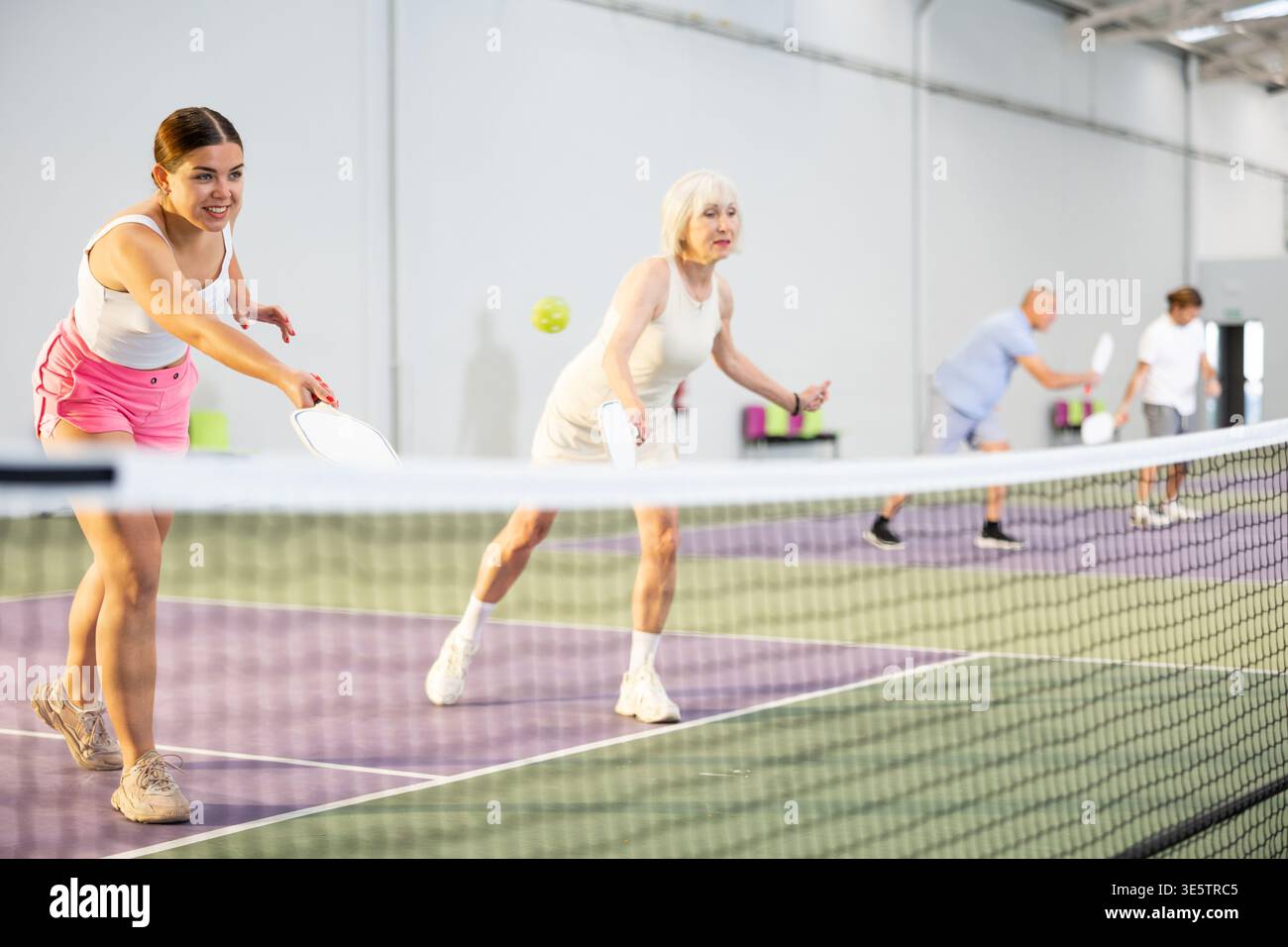 Donne che giocano a Pickleball tennis sul campo da Pickleball al coperto Foto Stock