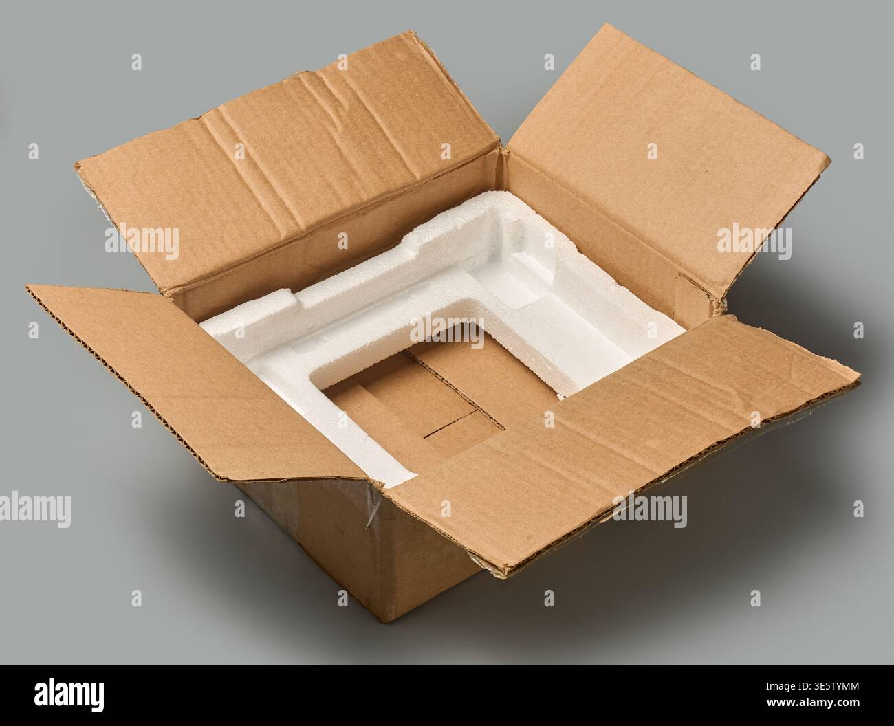 scatola di cartone aperta aperta marrone con sfondo grigio in polistirolo isolato, contenitore con inserto protettivo in polistirene bianco, modello mock-up Foto Stock