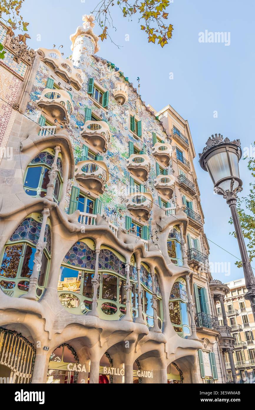 Barcellona, Spagna - 26 novembre 2021: Lampada di strada sullo sfondo dell'edificio Casa Batllo a Barcellona in autunno, verticale. Facciata colorata Foto Stock