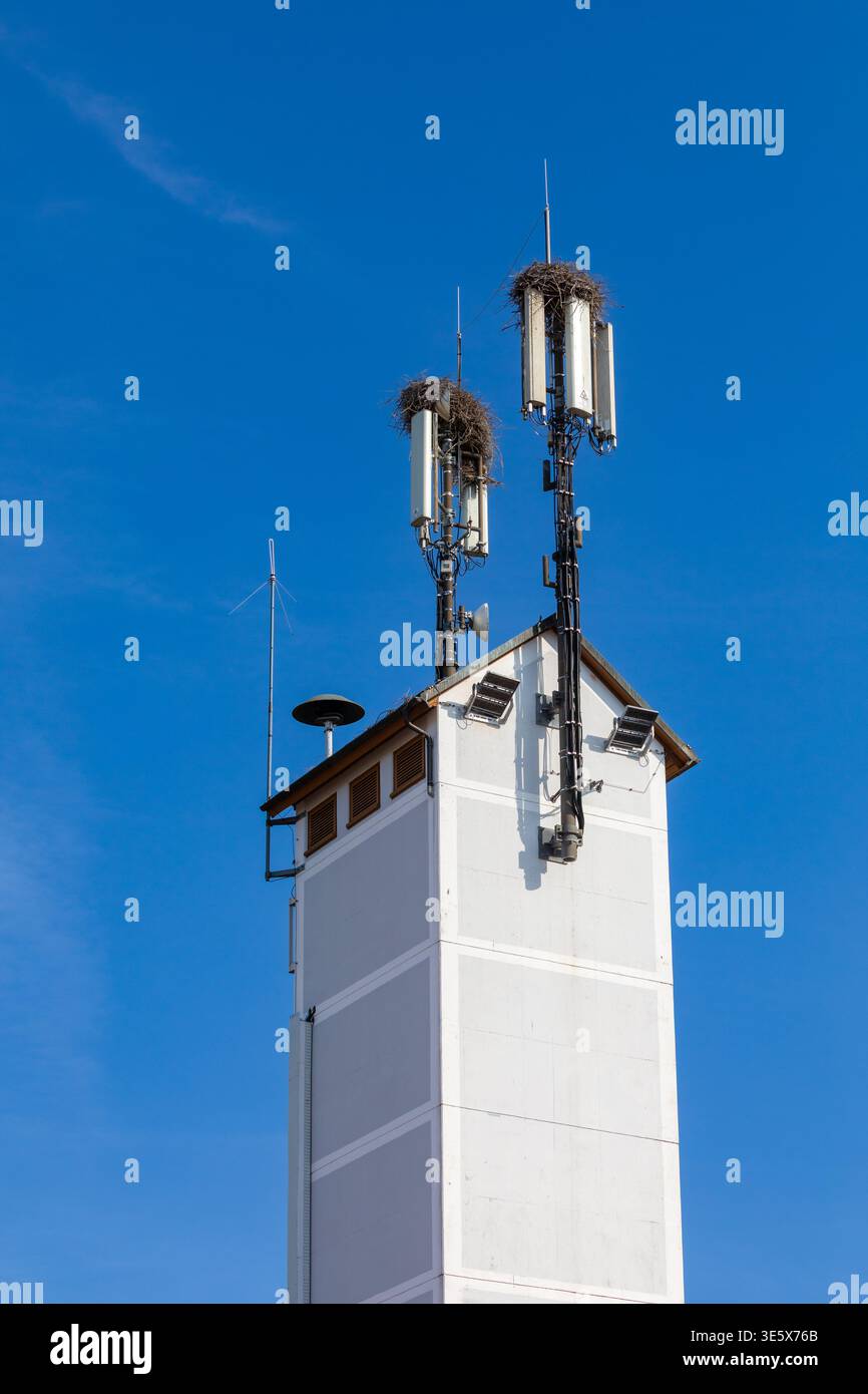 Torre cellulare con nido di cicogna su una torre in Germania Foto Stock