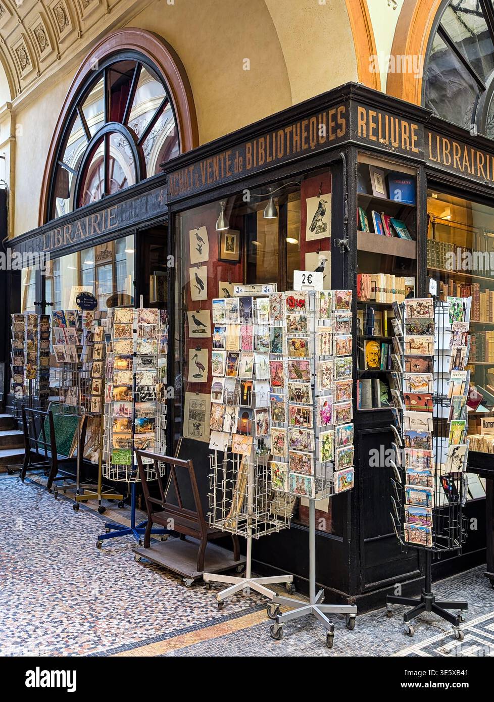 Cartoline d'epoca e libri antichi esposti all'esterno di una libreria antiquaria nascosta all'interno degli eleganti portici della Galerie Vivienne, a Parigi, in Francia Foto Stock