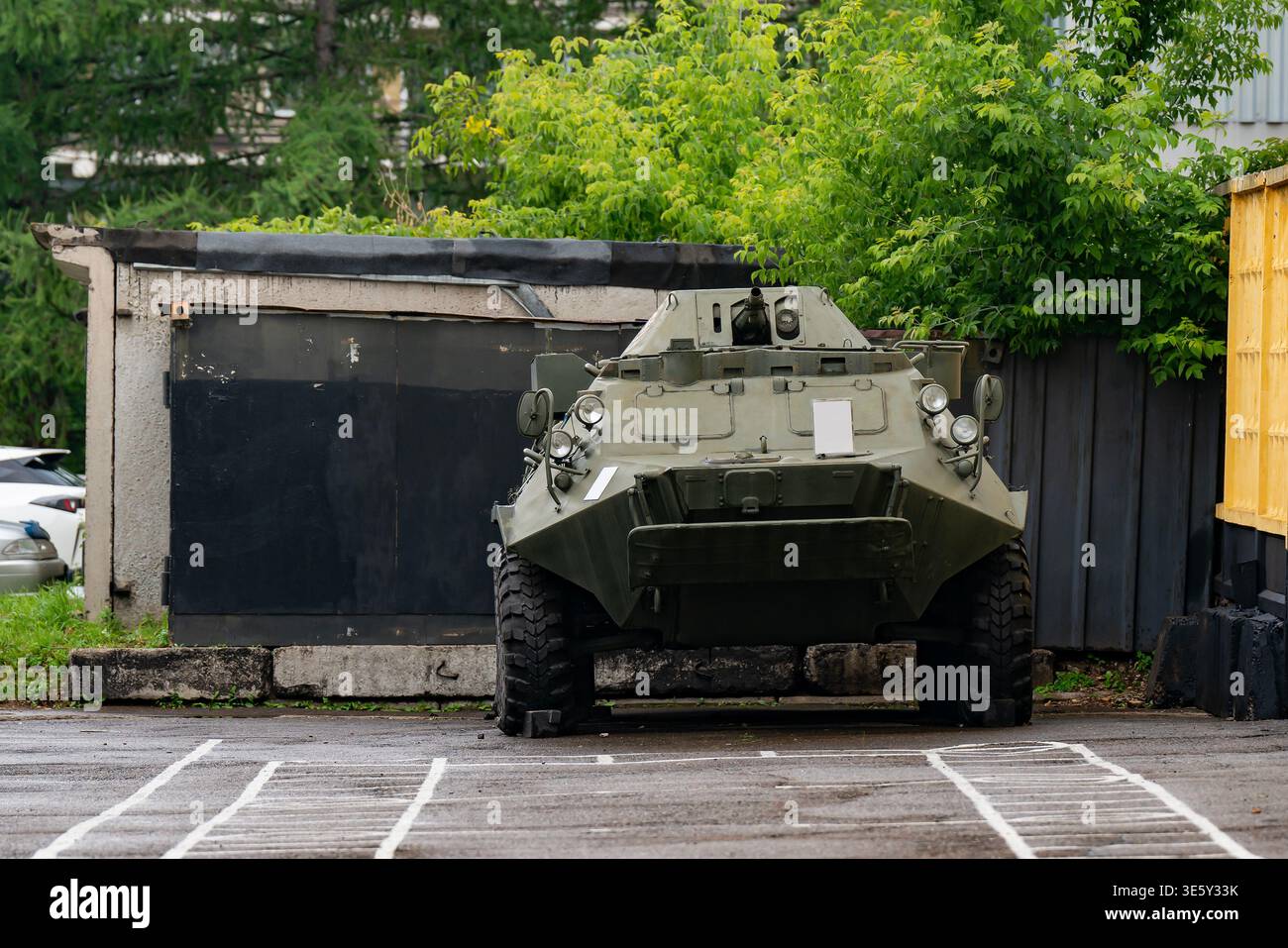 Mezzo blindato da trasporto truppe, veicolo militare parcheggiato in un garage urbana, vista frontale con mimetica verde Foto Stock