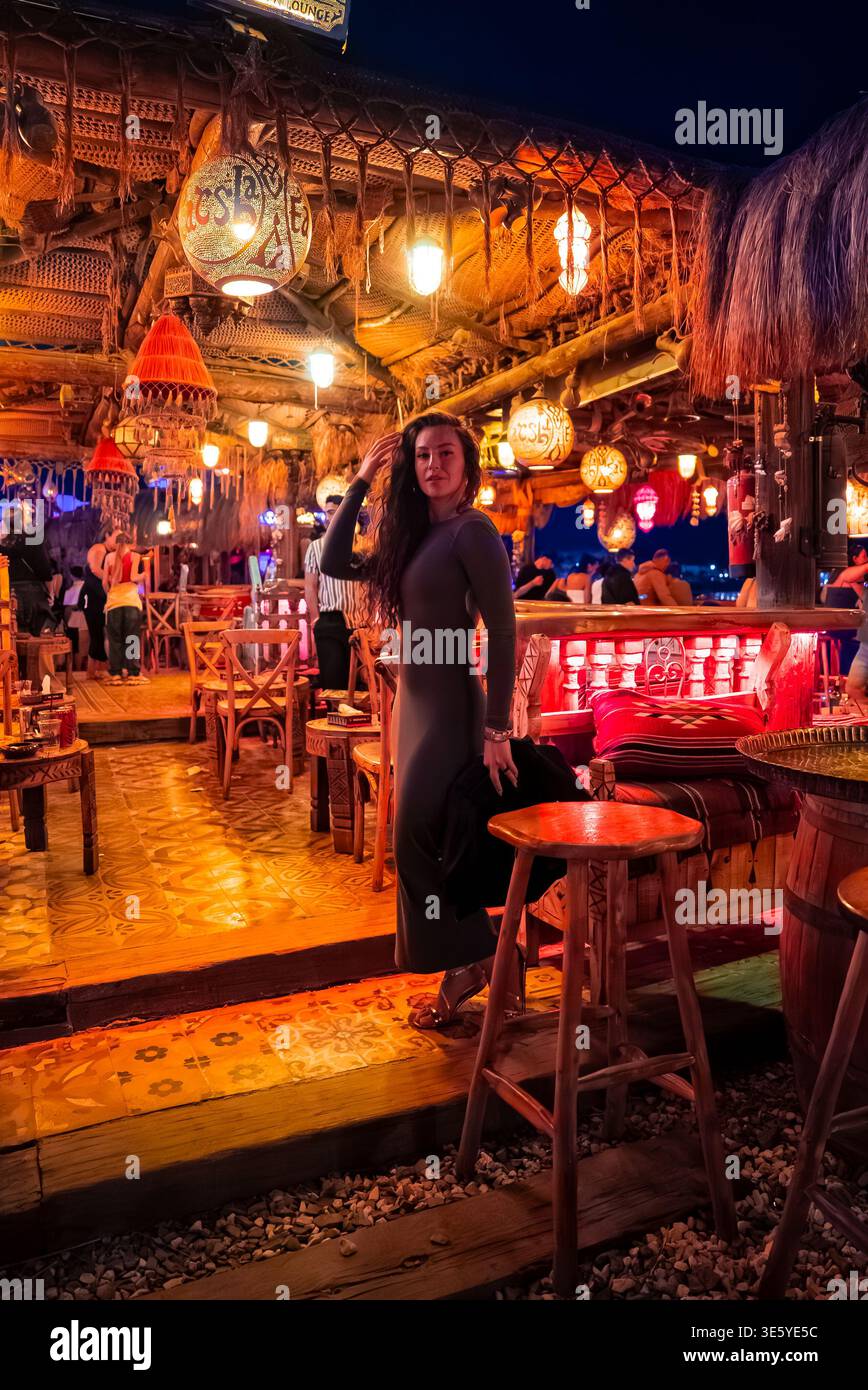 Donna in abito lungo e scuro al Farsha Mountain Lounge, Sharm El Sheikh Foto Stock