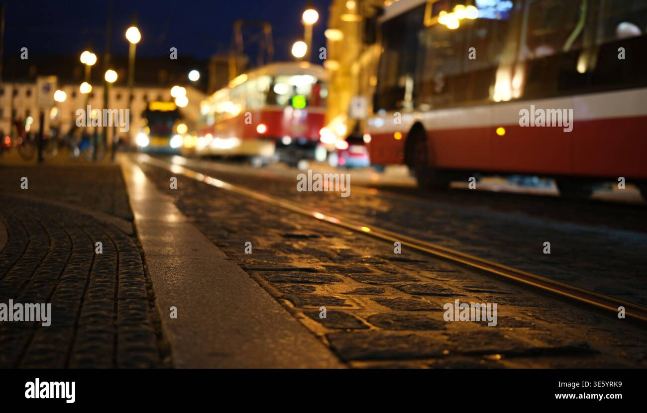 Traffico notturno su Una strada cittadina: Auto con luci che si accendono contro la città sfocata di Praga Foto Stock