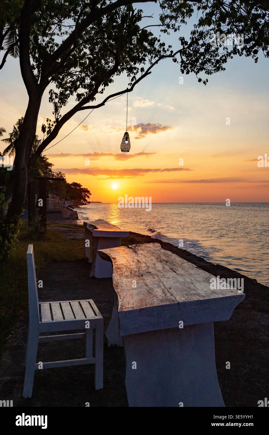 Tavolo e sedia in riva al mare, Bali, Indonesia, Sud-est asiatico. Tavolo e sedia per rilassarsi al tramonto, Bali, Indonesia. Foto Stock