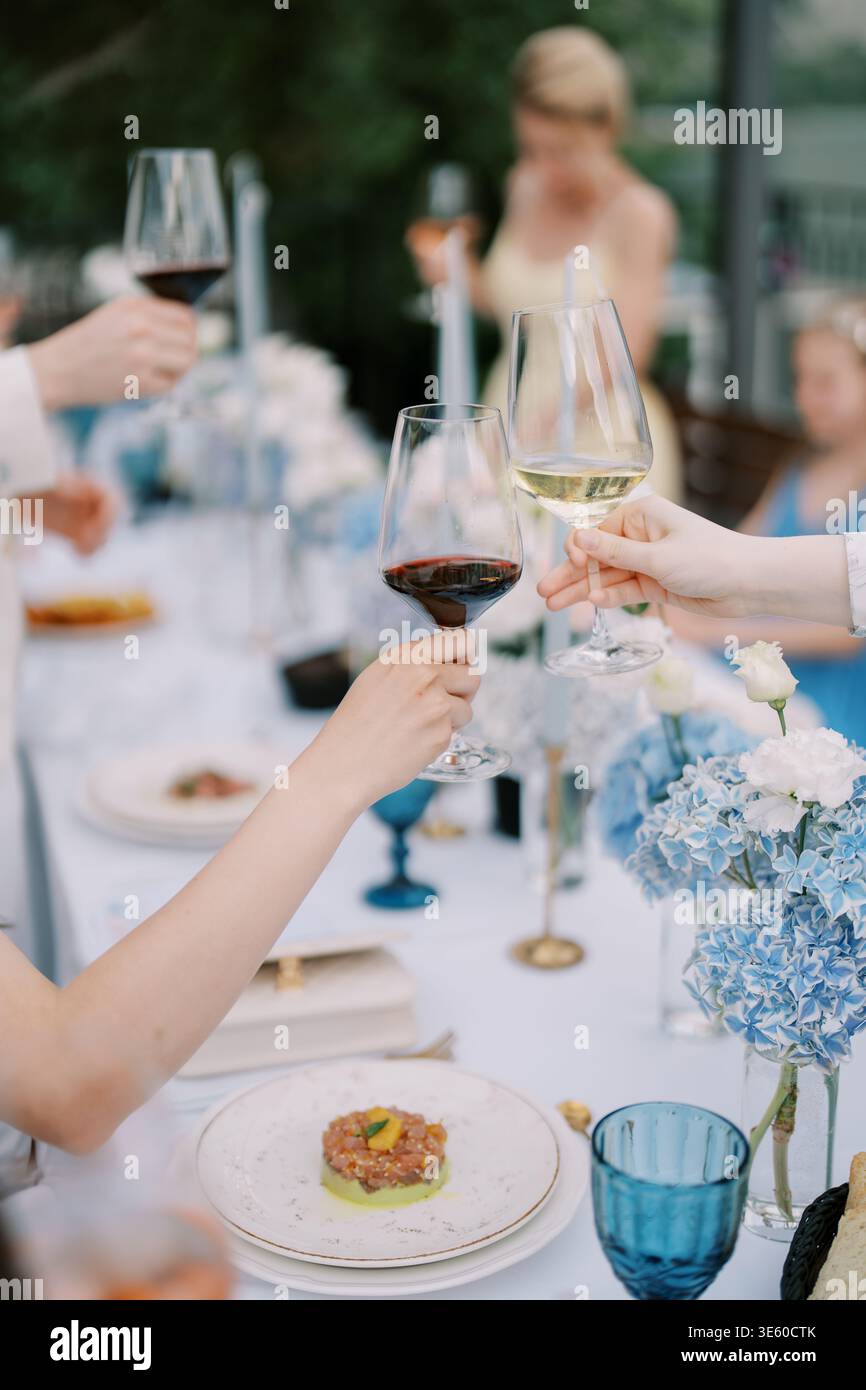 Festeggiamenti con gli occhiali. Gioioso incontro condividere cibo e Risate insieme Foto Stock