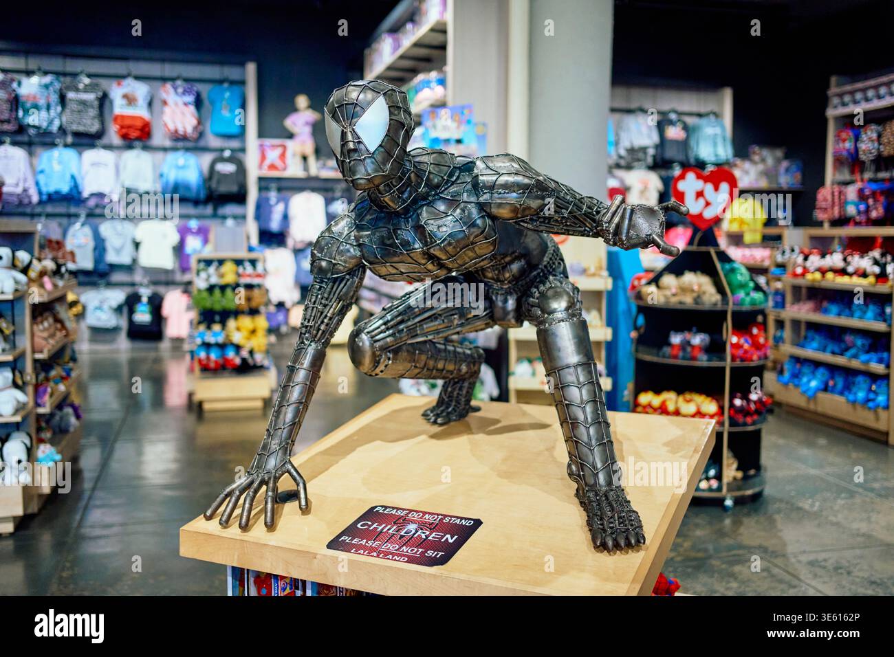 Statua a grandezza naturale di Spider-Man realizzata in rottami metallici in un negozio di souvenir. Ammira la scultura del supereroe in una posa accovacciata all'interno di un negozio al dettaglio. Foto Stock