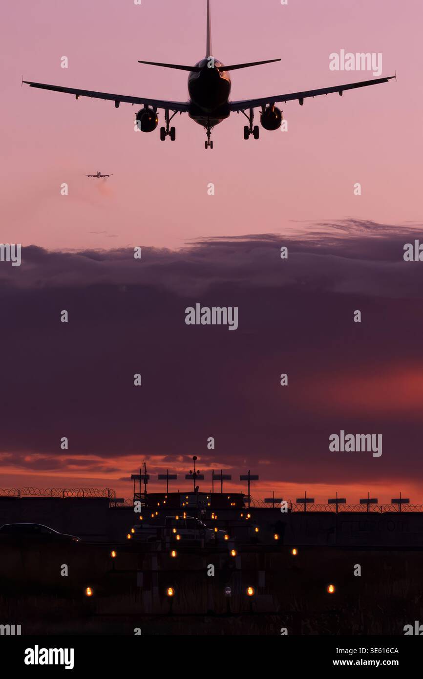 Airbus A320 atterra con luci di avvicinamento illuminate con un altro aeromobile sullo sfondo al tramonto Foto Stock