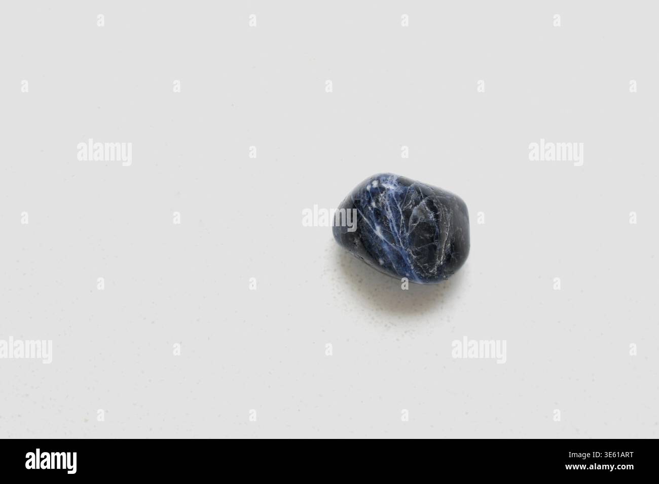 Vista dall'alto di una pietra di sodalite naturale che mostra toni blu profondi con venature bianche, evidenziando la sua esclusiva consistenza minerale. Ideale per i concetti Foto Stock