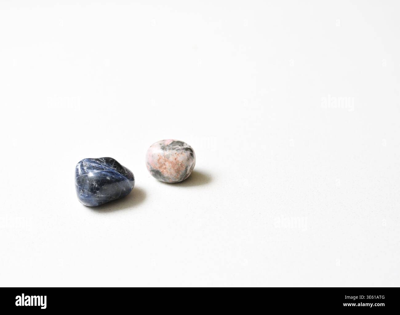 Cristalli naturali di Sodalite e rodocrosite disposti in una composizione estetica, che mostrano vivaci texture minerali blu e rosa. Foto Stock