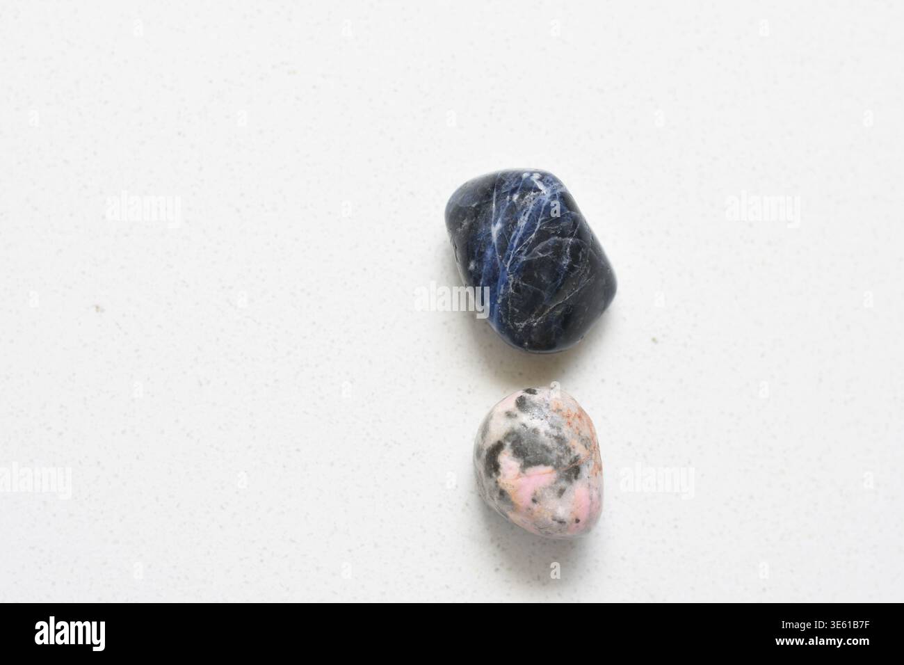 Cristalli naturali di Sodalite e rodocrosite disposti in una composizione estetica, che mostrano vivaci texture minerali blu e rosa. Foto Stock