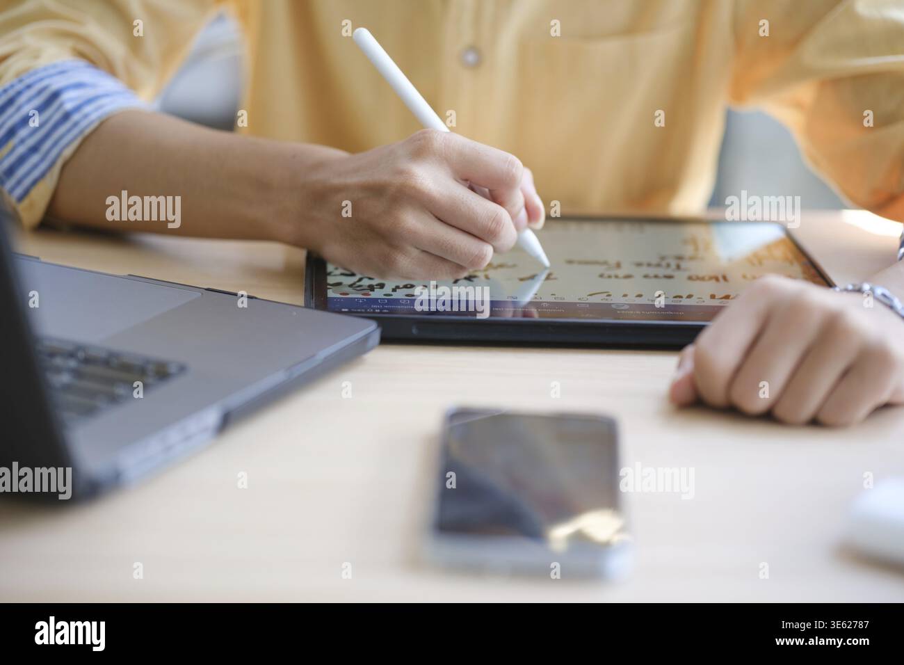 Web designer maschile che disegna con un tablet grafico al tavolo in ufficio, primo piano Foto Stock